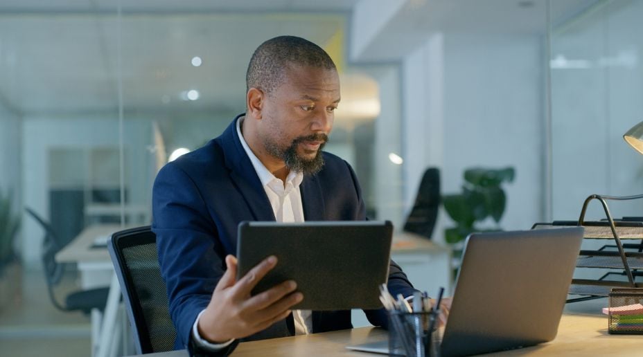 man working on a laptop and tablet