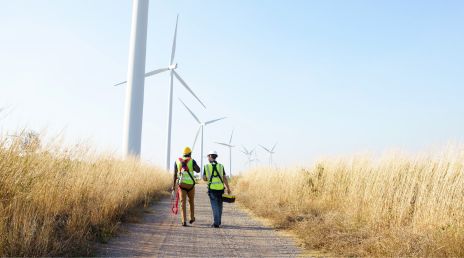 two engineers walking towards wind turbines