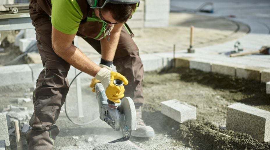 man using disc cutter to cut stone