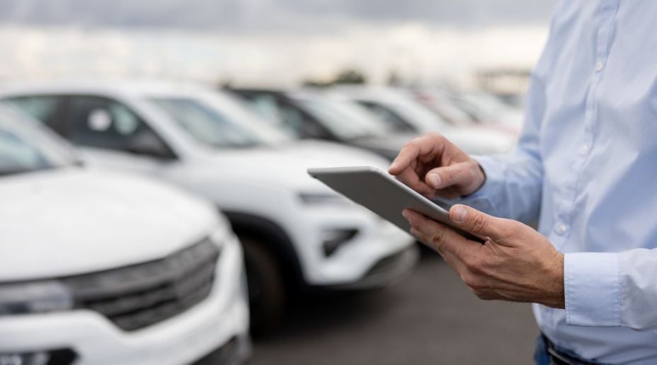 man on an ipad near cars