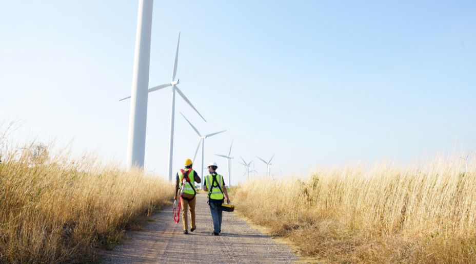 two engineers walking towards wind turbines